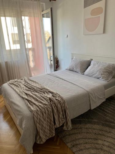 a bed in a bedroom with a large window at Nikola NS2 in Novi Sad