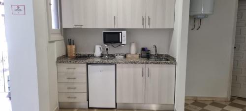a kitchen with white cabinets and a counter top at ADANAR-Las Columnas in Granada