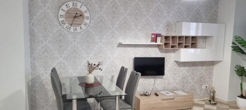 a dining room with a table and a clock on the wall at ADANAR-Las Columnas in Granada
