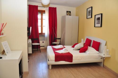 a bedroom with a white bed with red pillows at At Home Bed and Breakfast in Lucca