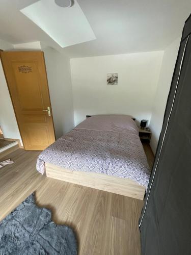 une petite chambre avec un lit et une porte en bois dans l'établissement Warm home, à Madonne-et-Lamarey