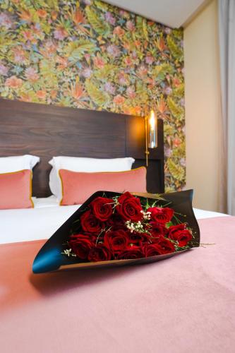 a tray of red roses sitting on a bed at Fourteen Hotel Ain Sebaa in Casablanca