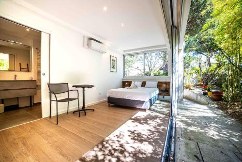 une chambre avec un lit, une table et une fenêtre dans l'établissement Logement de Prestige avec piscine Vue sur le Golf de la Grande Motte, à La Grande Motte