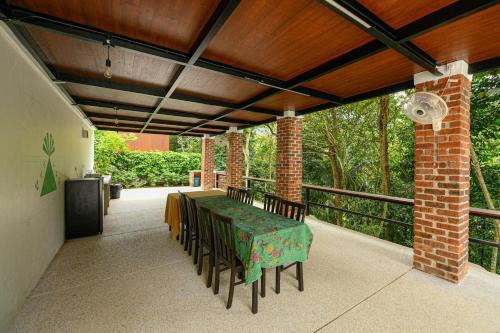a patio with a table and chairs on a balcony at The HIJAU Camp & Cabin in Gopeng