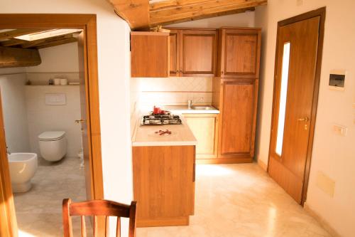 a kitchen with wooden cabinets and a counter top at Cav Costa degli Etruschi in San Vincenzo