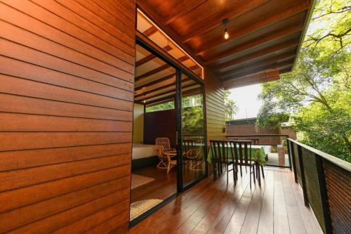 a wooden deck with a table and chairs on a balcony at The HIJAU Camp & Cabin in Gopeng