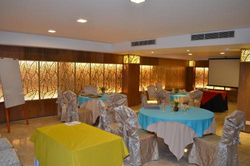 a conference room with tables and chairs and a screen at Lakeshore Hotel & Apartments in Dhaka