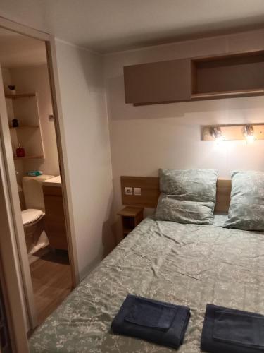 une petite chambre avec un lit et un miroir dans l'établissement Siblu Domaine de Kerlann mobile home LUMINOSA, à Pont-Aven