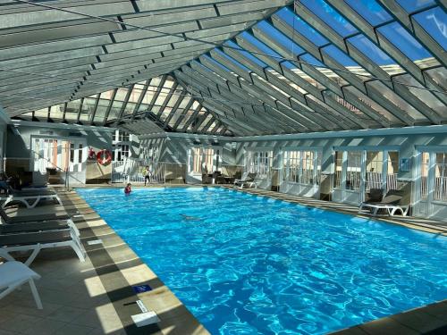 une grande piscine avec de l'eau bleue dans un immeuble dans l'établissement Appt familial 5 Pers avec Piscine et Tennis, à Le Touquet-Paris-Plage