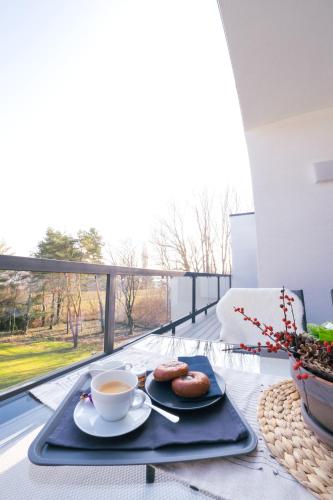 a tray with two cups of coffee and donuts on a table at Apartmán NAUTIS in Piešťany