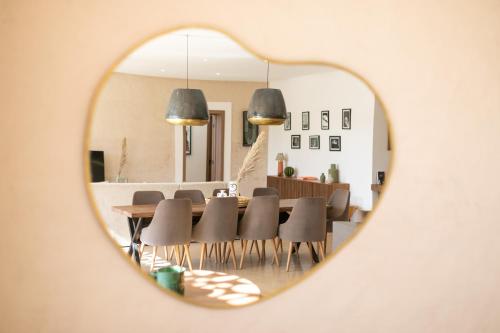 a dining room with a table and chairs seen through a mirror at Dar Al Ikhwa, Lodge de luxe à Marrakech in Sfiani