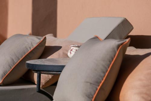 a bed with grey pillows and a table with a cup on it at Dar Al Ikhwa, Lodge de luxe à Marrakech in Sfiani