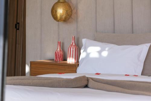 a bedroom with a bed with two vases on a table at Dar Al Ikhwa, Lodge de luxe à Marrakech in Sfiani