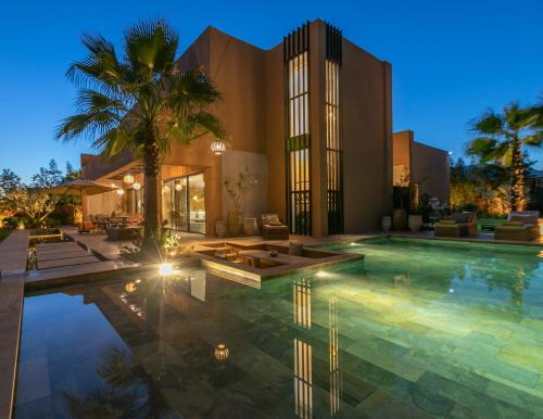 a house with a swimming pool in front of a building at Dar Al Ikhwa, Lodge de luxe à Marrakech in Sfiani