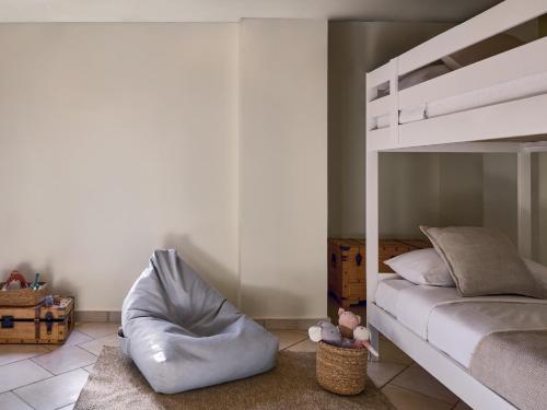 a bedroom with a bunk bed and a bean bag chair at Grecotel Plaza Beach House in Rethymno Town
