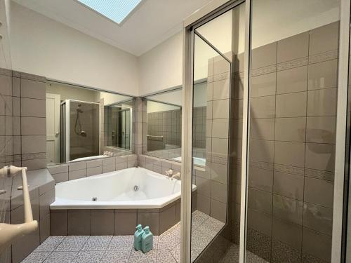 ein großes Badezimmer mit Badewanne und Dusche in der Unterkunft Peaceful cottage Burnside area in Burnside