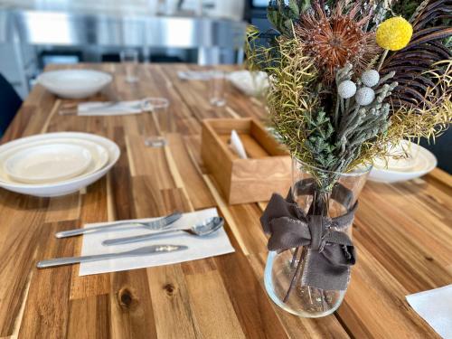 a wooden table with a vase of flowers on it at 無料送迎可 焚き火とBBQが楽しめる一棟貸しの宿 Acorn in Fujikawaguchiko