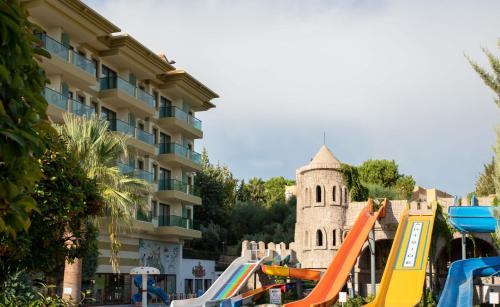 a sand castle and slides in front of a building at Adalya Art Side - Ultra All Inclusive in Side