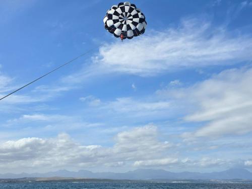 a kite flying in the sky over the ocean at Southern Cross Beach House in Groot Brak Rivier