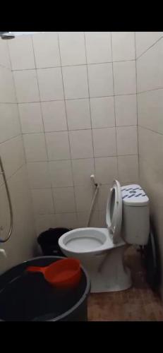 ein Badezimmer mit einer weißen Toilette in einem Zimmer in der Unterkunft Villa Brastagi Gunung Mas B7 in Berastagi