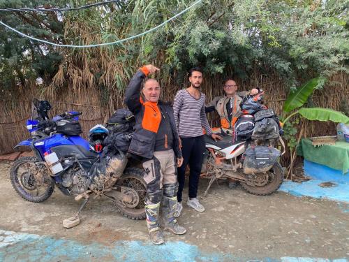 a group of three men standing next to motorcycles at Maison d'hotes oued el Makhazine chez Bilal in Mimouna