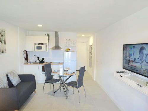 a kitchen and a living room with a table and chairs at Estudio Playa Jardín in Puerto de la Cruz
