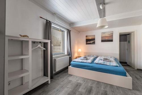 a bedroom with a bed and a window at Das weiße Stadthaus in Wesselburen