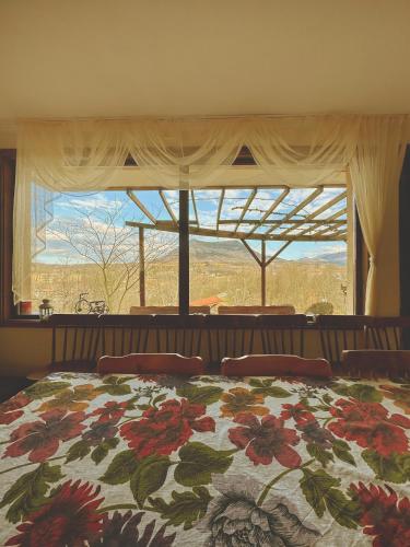 a bedroom with a bed and a large window at Къща за гости "Вила Релакс" in Apriltsi