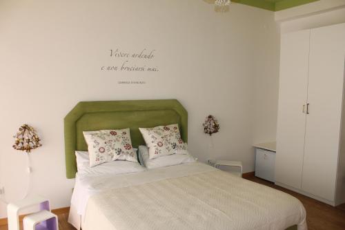 a bedroom with a bed with a green headboard at La Dimora del Conte in Pescara