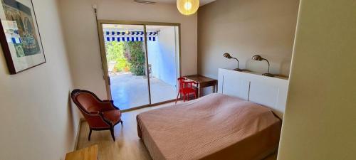 une chambre avec un lit et une porte coulissante en verre dans l'établissement L'HORIZON - 90m2 - Belle vue - Centre - Parking - 3 Chambres, à Cassis