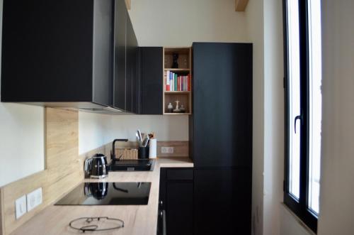- une cuisine avec des armoires noires et une cuisinière dans l'établissement T2 Cannes centre, à Cannes