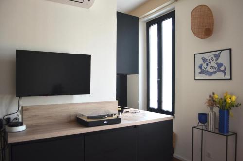 un salon avec une télévision à écran plat sur un mur dans l'établissement T2 Cannes centre, à Cannes