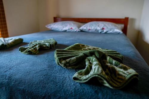 a blue bed with two towels on top of it at Pousada Porto Belo in Porto Belo