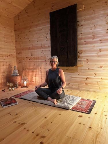 a woman sitting on the floor in a room at Yngsjö Havsbad in Yngsjö