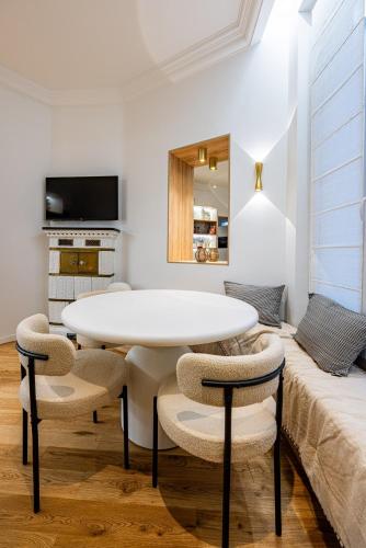 une salle à manger blanche avec une table et des chaises dans l'établissement 2BR-2Bathrooms-6Pers-Montparnasse-Paris 15-AC, à Paris
