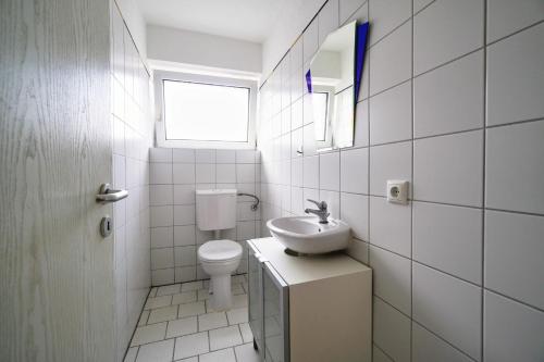 a white bathroom with a sink and a toilet at Premium Apartment in Tiddische