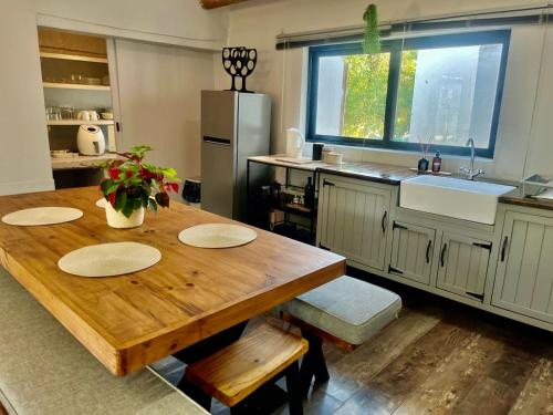 a kitchen with a wooden table and a refrigerator at Hephzibah Inn Farm Cottage in Hermon