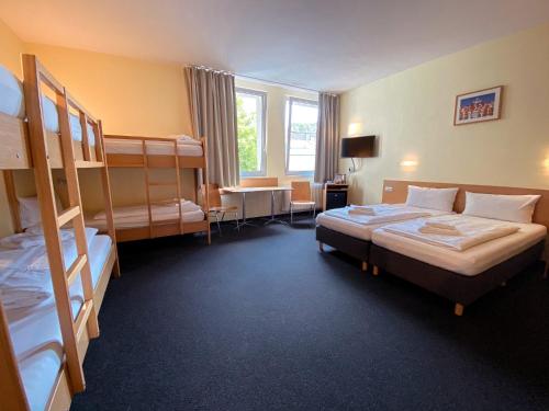 a hotel room with two bunk beds and a desk at Familienhotel Citylight in Berlin