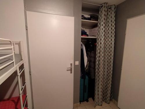 un placard avec une porte menant à une chambre dans l'établissement Appartement Etel, à Étel