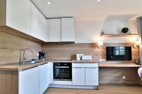 une cuisine avec des armoires blanches et un évier dans l'établissement Paulette 14 - A Sables d'Or les pins proche plage, à Fréhel