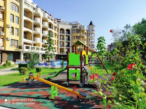 a playground in a park in front of a building at Diamond Palace in Sunny Beach