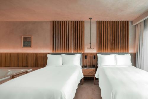 two beds sitting next to each other in a room at Almare, a Luxury Collection Resort, Isla Mujeres, Adult All-Inclusive in Isla Mujeres