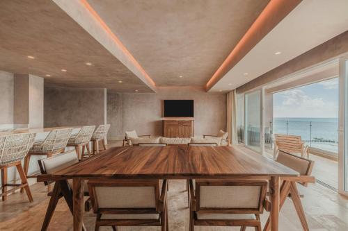 a dining room with a table and chairs and the ocean at Almare, a Luxury Collection Resort, Isla Mujeres, Adult All-Inclusive in Isla Mujeres
