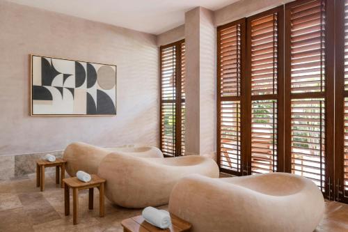 a living room with couches and tables and windows at Almare, a Luxury Collection Resort, Isla Mujeres, Adult All-Inclusive in Isla Mujeres