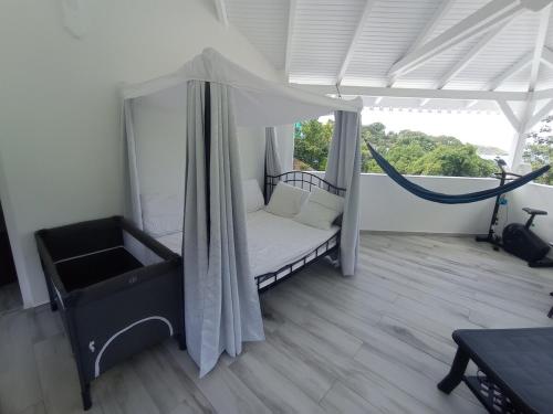 a room with a bed with a hammock in it at Villa blue lagoon T5 4 chambres vue mer, 100m plage, jacuzzi, espace jeu in La Trinité