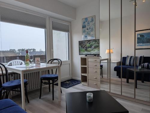 a living room with a table and a dining room at Appartment-19-Sylter-Robbe in Wenningstedt