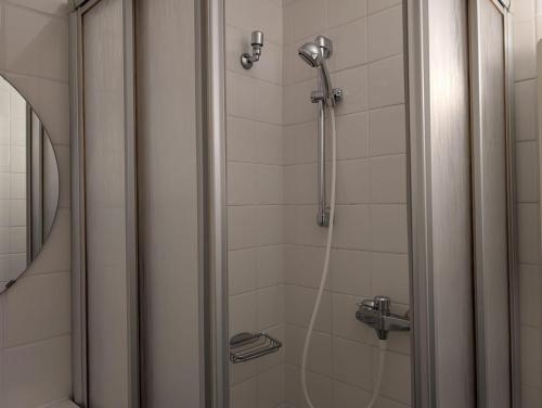 a shower with a hose in a bathroom at Appartment-19-Sylter-Robbe in Wenningstedt