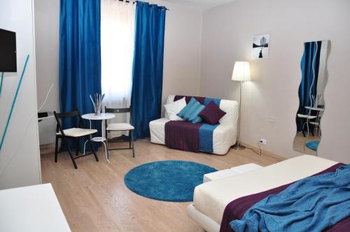a bedroom with a bed and a couch and a table at At Home Bed and Breakfast in Lucca