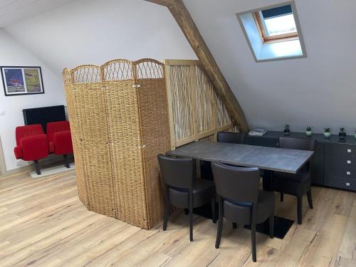 une salle à manger avec une table et quelques chaises dans l'établissement Appartement vintage - Terrasse - Fauteuils de cinéma, à Verton