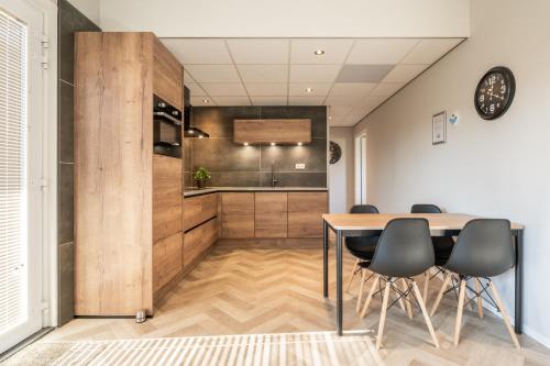 een keuken en eetkamer met een tafel en stoelen bij Vakantiewoning aan het water in Yerseke in Yerseke